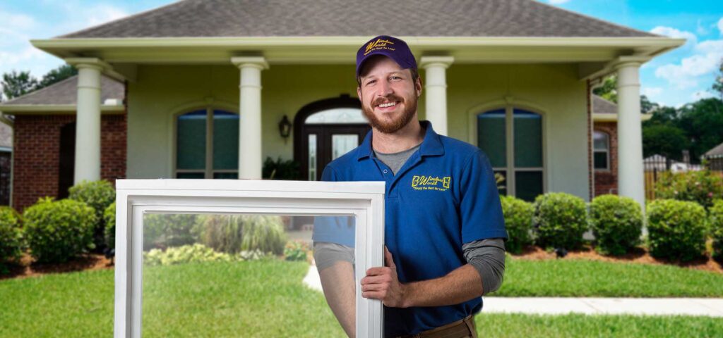 window world employee holding window in front of house